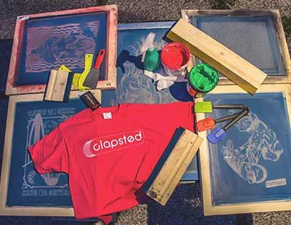 Printed shirts and screens on a work table