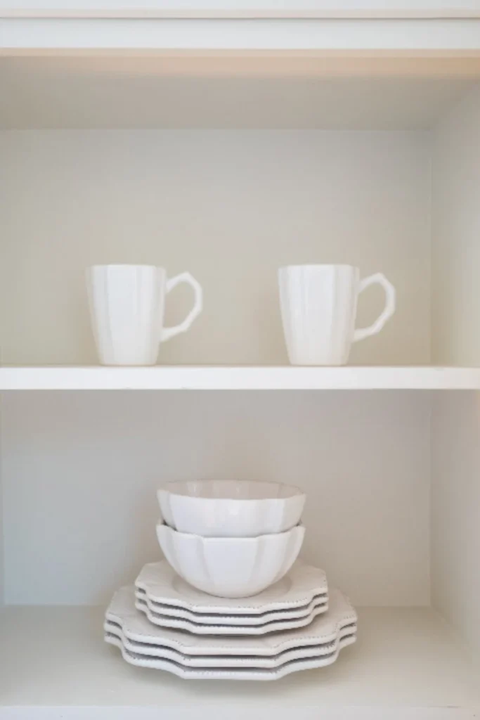 White mugs and bowls on a kitchen shelf