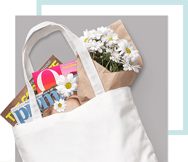 A white tote bag filled with flowers and magazines