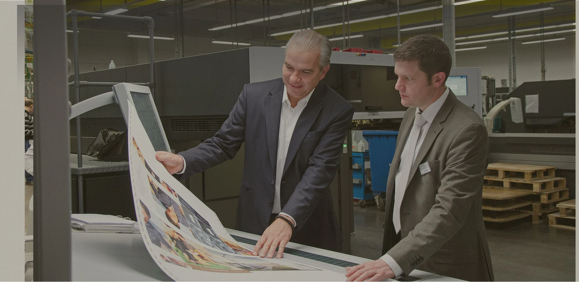 Two printers checking a printed proof