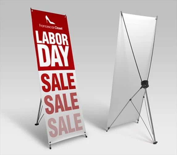 X-banner stand with a printed sale graphic